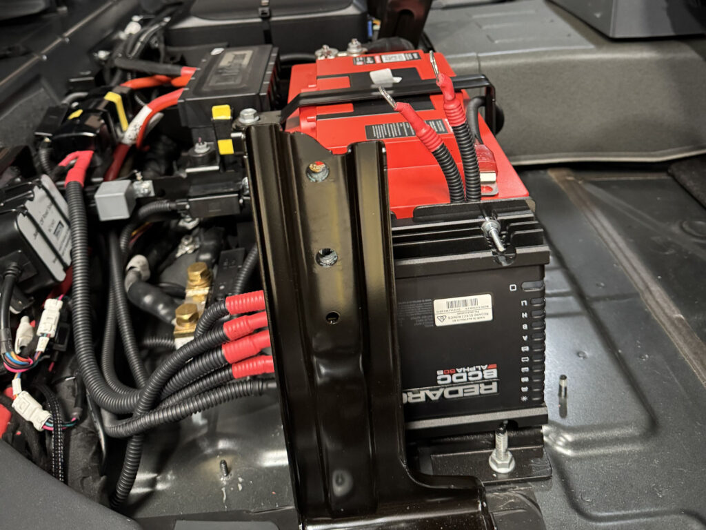 A REDARC Alpha50 BCDC charger is secured with custom brackets, managing efficient power distribution for off-road travel