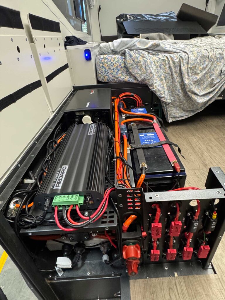 An overhead view of the upgraded electrical locker featuring the REDARC Alpha BCDC50, 2000W inverter, and the 700Ah PowerPaul battery bank