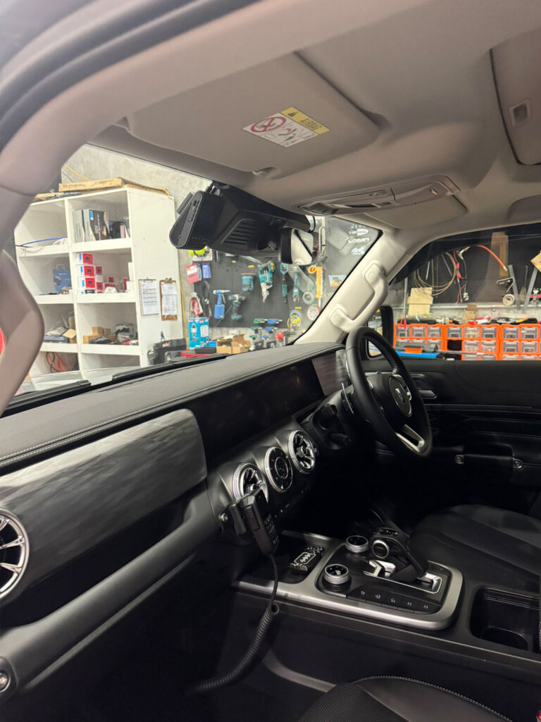 Uniden X76 remote microphone mounted to the lower dash console, offering convenient driver access without cluttering the cabin.