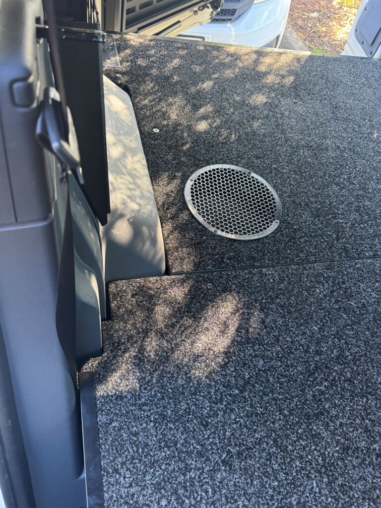 Ventilated metal speaker grille integrated into the deck