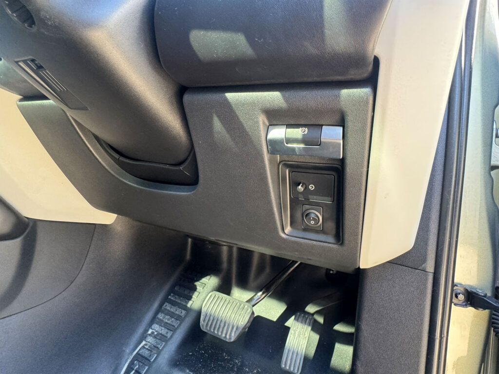 Circular auxiliary light override switch cleanly integrated into the driver-side lower dash panel
