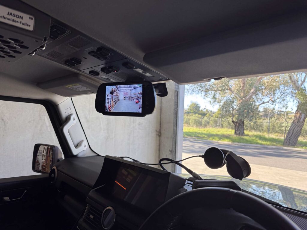 Safety Dave 7-inch AHD replacement mirror monitor mounted in the cabin, displaying a clear real-time video feed from the rear canopy camera